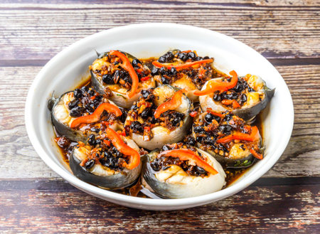 Steamed white eel with black bean sauce served in bowl isolated on wooden table side view of hong kong foodの写真素材