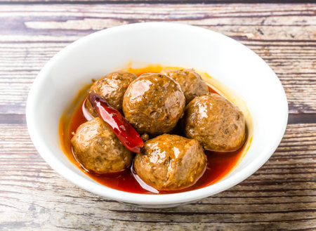 Braised Spicy beef tendon balls served in bowl isolated on wooden table side view of hong kong foodの写真素材