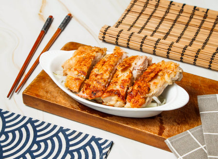 Italian Chicken Leg Steak Slice with chopsticks served in dish isolated on wooden board and napkin side viewの写真素材