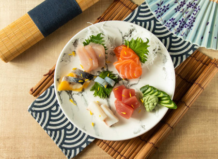 Assorted Comprehensive Sashimi with Dory sashimi, salmon sashimi, Tuna fish, swordfish served in plate isolated on napkin top view on wooden background of Japanese foodの写真素材