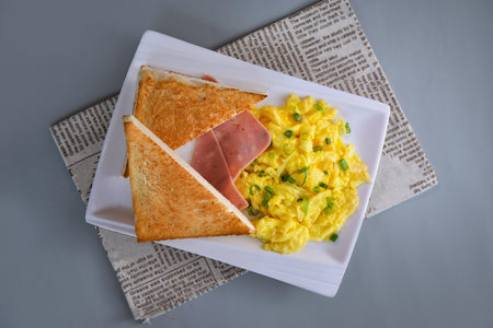 Fried egg toast with chopped green onion and ham breakfast served in dish isolated on napkin top view of chinese food on grey backgroundの写真素材