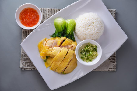 Hainan Chicken Rice with pickled vegetables and sauce served in dish isolated on napkin top view of chinese food on grey backgroundの写真素材