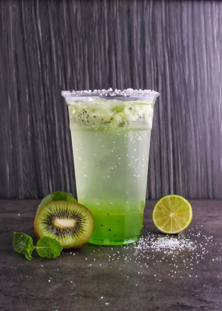 Refreshing Kiwi Mojito made with fresh kiwi slices, lime juice, mint leaves, and sparkling water served in glass isolated on background side view of healthy drinkの写真素材
