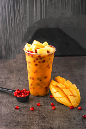 Mango Pomegranate Smoothie served in glass isolated on dark background side view of delicious and satisfying beverageの写真素材