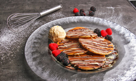 Belgian Decadent Chocolate Pancakes with Fresh raspberries, blackberries and Ice Cream served in plate isolated on table side view of indulgent dessertの写真素材