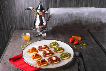 Colorful mix Mini Pancake Platter topped chocolate, pistachio, caramel, and strawberries served in plate isolated on napkin side view of dessertの写真素材
