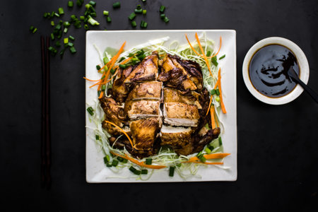 Whole Roasted Chicken with spring onion, carrots and soy sauce served in dish isolated on dark background top view of chinese foodの写真素材