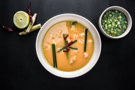 Thai Soup served in bowl with spring onion and green chilli isolated on dark background top viewの写真素材