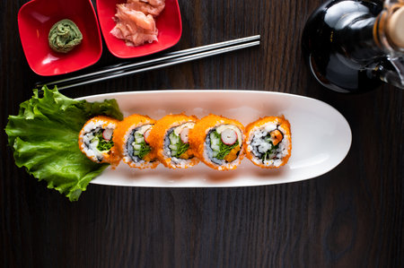 California Maki roll include rice, shrimp and lettuce leave with chopsticks served in dish isolated on wooden table top viewの写真素材