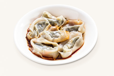 Dumplings, Wontons, Shao Mai, Vegetarian Mushroom Wontons with spicy Sauce served in plate isolated on grey background side view of hong kong foodの写真素材