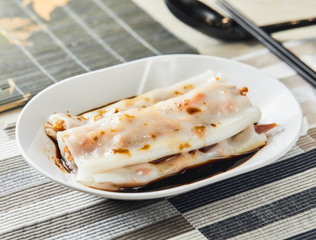 Barbecued pork rice roll with sauce served in tray isolated on napkin side view of chinese foodの写真素材