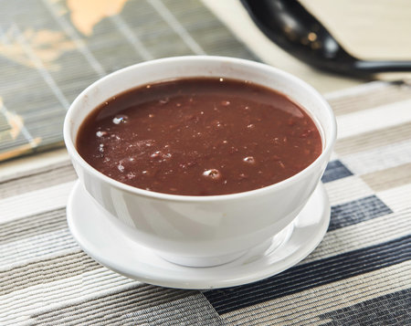 Red bean paste served in bowl isolated on napkin side view of chinese food