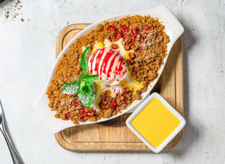 Apple Crumble with vanilla ice cream, mint and dip served in dish isolated on wooden board on background top view of italian foodの写真素材