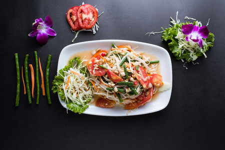Vermicelli Salad include, tomato, cabbage, carrot, lettuce leaves and peanuts served in dish isolated on dark background top view of thai foodの写真素材