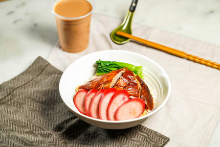 Chinese Sausage and Roasted Duck with Rice with chopsticks and spoon served in bowl isolated on napkin side view on marble backgroundの写真素材