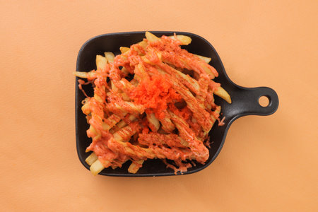French Fries topping with Mentaiko served in dish isolated on background top view of fastfood potato...