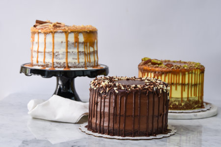 Assorted Gourmet Cakes including Caramel Fig, Pistachio Caramel, and Chocolate cake with napkin side view of assortment of elegant classic cafe dessertsの写真素材