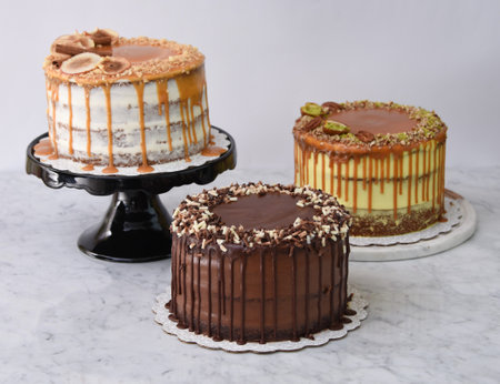 Assorted Gourmet Cakes including Caramel Fig, Pistachio Caramel, and Chocolate cake side view of assortment of elegant classic dessertsの写真素材