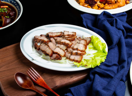 Grilled Salted Pork with spoon and fork served in dish isolated on wooden board side view of taiwan foodの写真素材