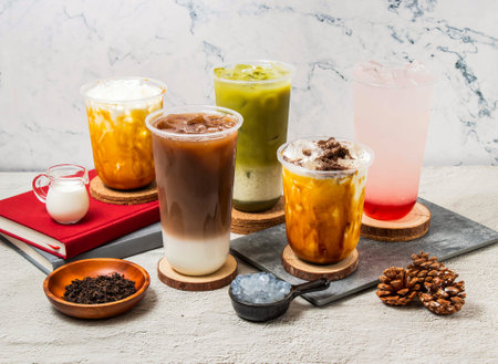 Assorted Taiwan iced tea Oolong milk Latte, Green tea latte, Strawberry Lemon tea, ice Oreo milk tea, served in disposable glass isolated on board side view of taiwanese iced drinkの写真素材