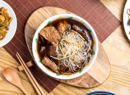 Angelica Vermicelli Rice Noodles Soup and Braised Tofu served in bowl with chopsticks and spoon isolated on wooden board top view of taiwan foodの写真素材
