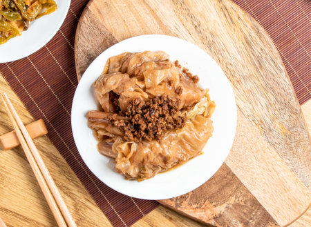 Braised Cabbage with minced Pork meat served in plate with chopsticks and spoon isolated on wooden board top view of taiwan foodの写真素材