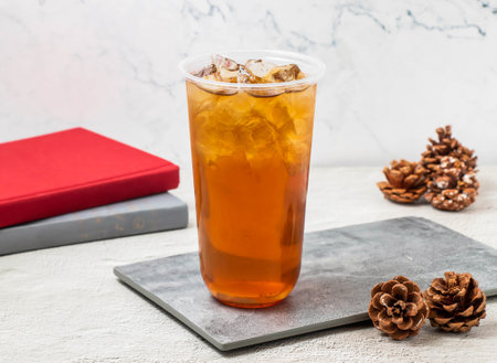 Spring Plum and Winter Melon iced tea served in disposable glass isolated on board side view of iced drinkの写真素材