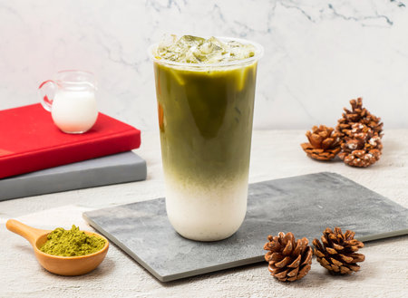 Iced Green tea latte served in disposable glass isolated on board side view of taiwanese iced drink