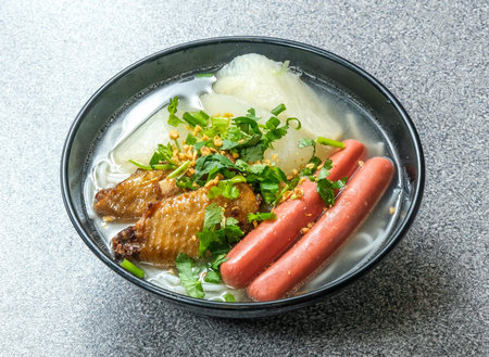 Savor a delicious bowl of sausages noodles and herbs in savory soup, perfect for a comforting meal