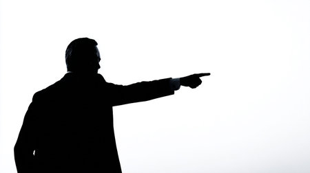Silhouette of a man pointing his finger at something on a white backgroundの素材