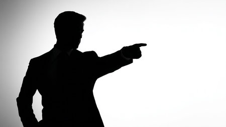 Silhouette of a businessman pointing with his finger on white backgroundの素材