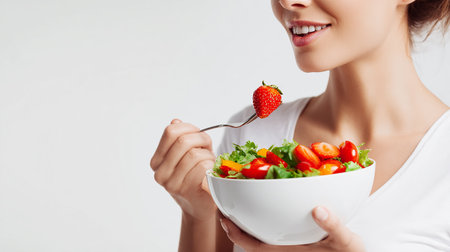 Young woman eating fresh salad on white background. Healthy food concept.の素材