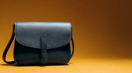 Black leather bag on a yellow background. Copy space for text.の素材