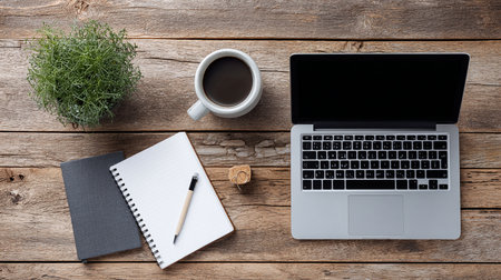 Laptop with notebook and cup of coffee on wooden table. Top viewの素材
