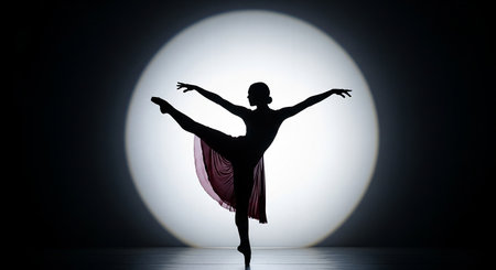 Silhouette of ballerina standing in front of white lightの素材
