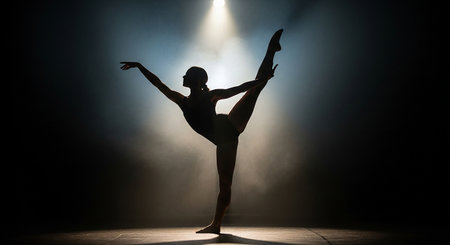 Young beautiful ballerina dancing in the studio on a dark backgroundの素材