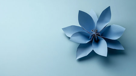 Origami flower made of paper on blue background. Minimal conceptの素材