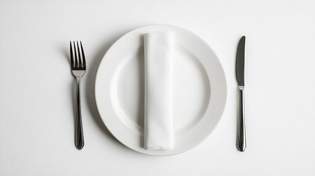 Empty plate with knife and fork on white background. Top view.の素材