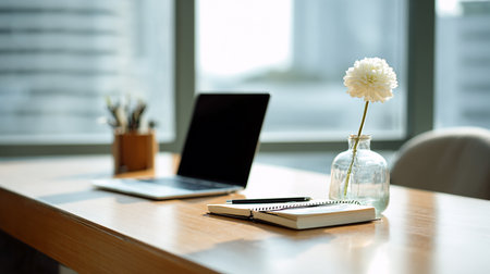 Laptop, notebook and flower on a wooden table in the officeの素材