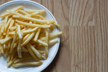 Potatoes fries on a little white paper bagの写真素材