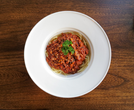 Italian spaghetti with a meat sauce on a white plateの写真素材