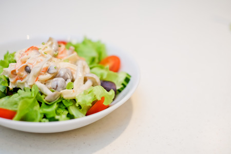 Fresh mixed salad , salad leaves and other vegetables, on the tableの写真素材