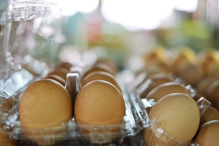 A lot of brown  fresh eggs, in box at a marketの写真素材