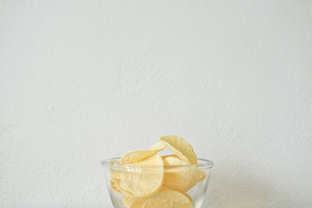 snack food of potato chips crispy  in white ceramic bowl  on white backgroundの写真素材