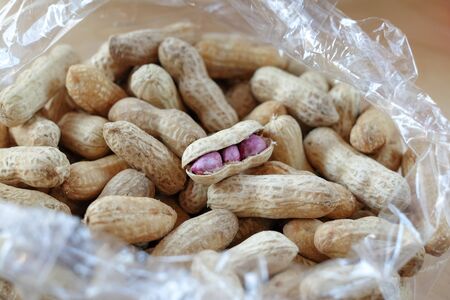 Many boiled peanuts packed in clear plastic bags on wooden floors