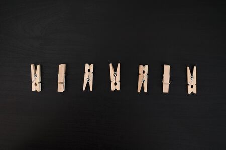 Brown wood clothes peg or clothespin on black backgroundの写真素材