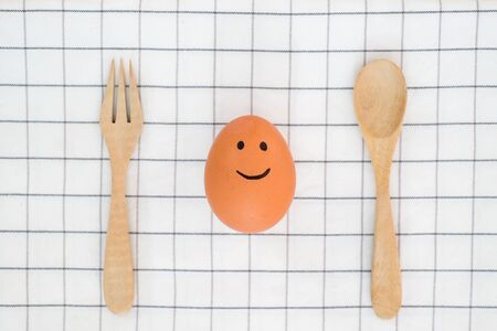 brown egg with happy face on the table breakfast in the morning , eating healthy food concept
