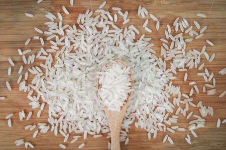 rice grains on wooden spoon , closeup rice healthy food on the tableの写真素材