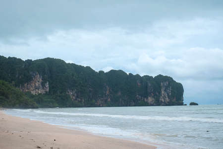 Sea at Ao Nang Beach during the windy overcast day in the low season, Cloudy sky above other islands of Krabi, Thailandの写真素材