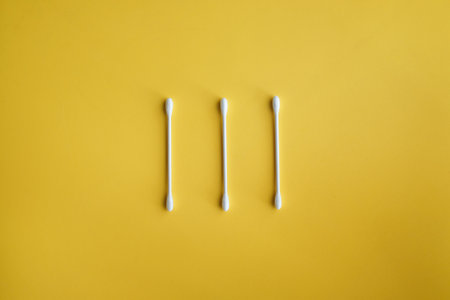 Close up of cotton Buds, White cotton ear sticks on yellow backgroundの写真素材